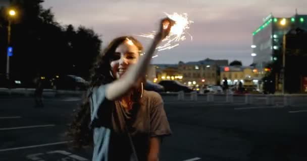 Adolescente avec scintillant dansant dans la rue de nuit en face du parking 4K — Video