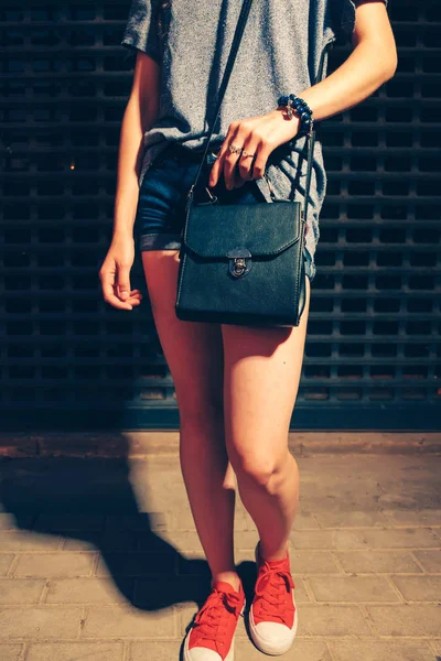 Hippi kız poz önünde kapalı gece kulübü kapı içinde kırmızı eğitmenler ile siyah çanta