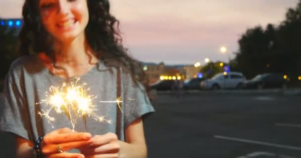 慢动作快乐的女孩跳舞与 sparcler 在城市日落 — 图库视频影像