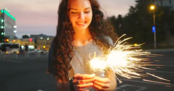 Menina alegre com sparkler no horário de pôr do sol da cidade — Vídeo de Stock