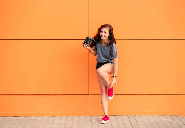 Tam trendy kız ile turuncu zemin üzerine vintage fotoğraf makinesi gövdesi — Stok fotoğraf