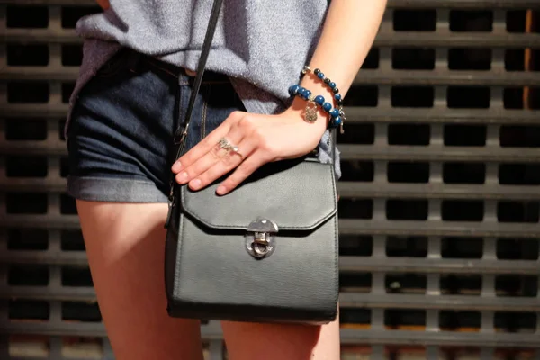 Menina na moda com bolsa preta e calções jeans — Fotografia de Stock