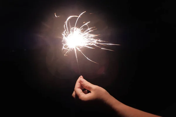 Female hand holding a burning sparkler — Stock Photo, Image