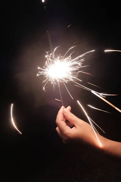 Female hand holding a burning bengal sparkler — Stock Photo, Image