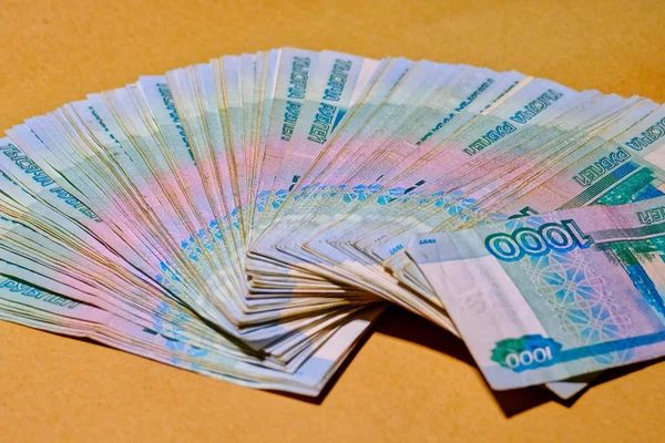 Billets russes 1000 roubles sont répartis comme un ventilateur sur un papier artisanal — Photo