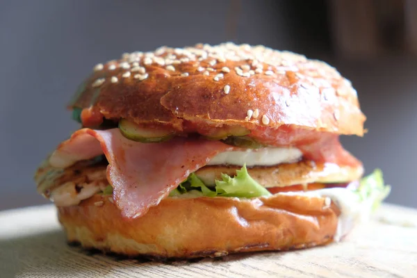 Burger artisanal avec balise, laitue et légumes sur panneau d'ardoise. Aliments malsains . — Photo