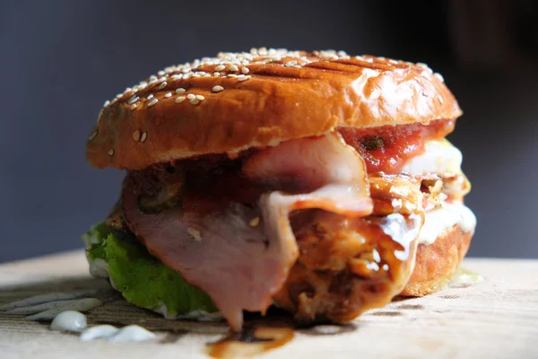 Čerstvé chutné burger na dřevěný stůl detail boční pohled — Stock fotografie