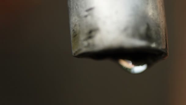 Macro slow motion shot of dripping water tap against dark background — Stock Video