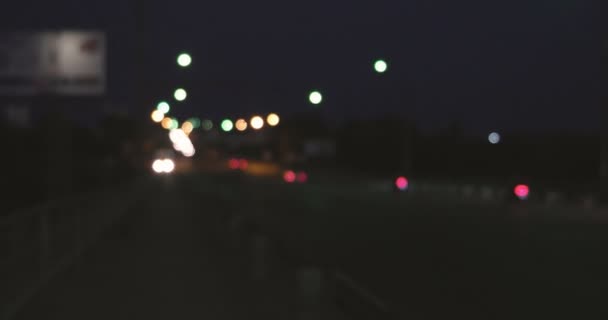 Абстрактный городской пейзаж размыл фон. Ночной вид на современную эстакаду, заполненную освещенными автомобилями и рельсами — стоковое видео