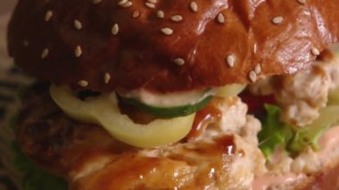 Burger fryed tavuk etli domates salatalık ve ağır çekim dönüm marul üzerinde yalan