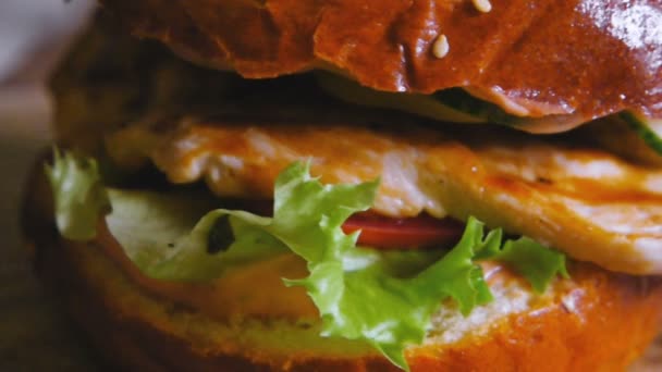 Deliciosa hamburguesa girando sobre la mesa muy cerca dof plano superficial — Vídeos de Stock