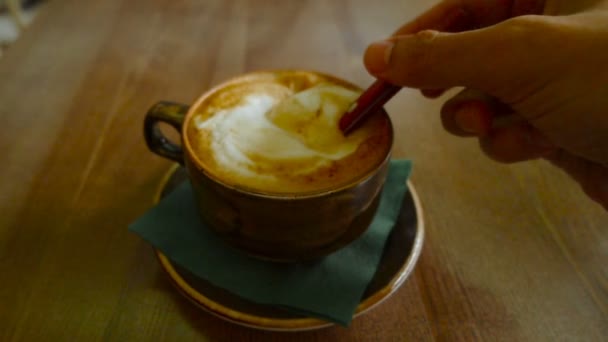 Man mixing cappuccino coffee in cup — Stock Video