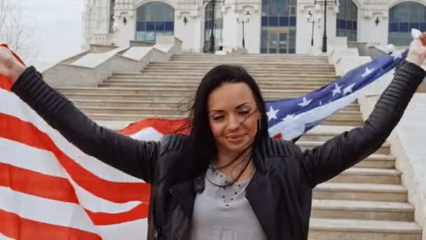 Латиноамериканка с волнообразным флагом США в руках — стоковое видео