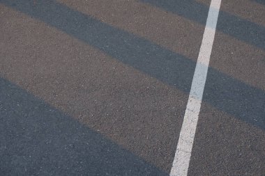 Trafik hattı üzerinden yol yeni asfalt yüzeyi günbatımı ışık yapı aracılığıyla parlayan desenleri ile boyalı