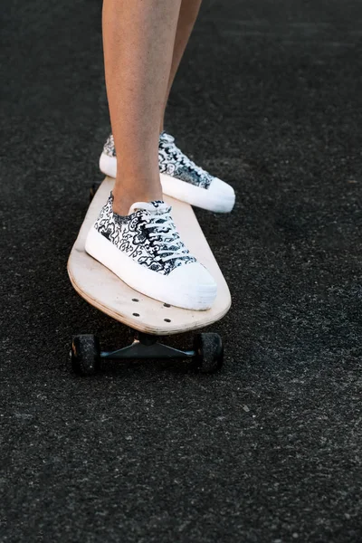 Vue de face des jambes femme skateboarder avec copyspace, planche à roulettes au lever du soleil ville — Photo