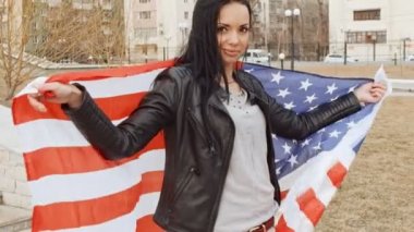 Onu geri kameraya bakıyor ve gülümsüyor arkasında elinde Amerika Birleşik Devletleri bayrak wavin ile Latin kız
