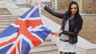 Göçmen vatansever eylemci. Latin kız kameraya bakarak ve Fhd görüntü gülümseyen elinde sallayarak Büyük Britanya bayrağı ile