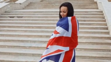 Mutlu kadın önünde merdivenlerden yukarı doğru giden union jack bayrak sarılı