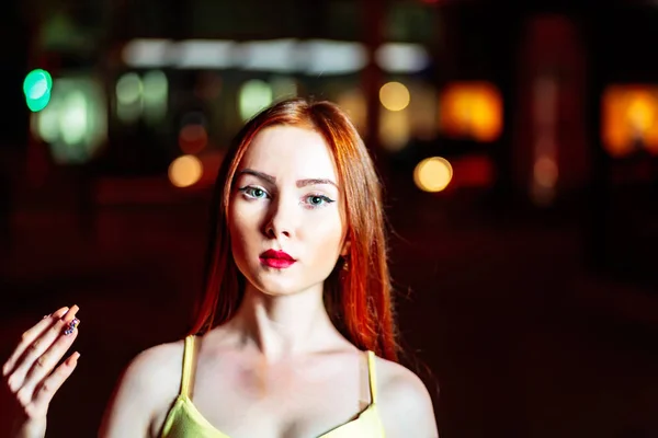 Red haired girl raise her hand with fancy nail art in front of dark night city background — Stock Photo, Image