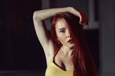 Kızıl saçlı kız, gece şehir ortamda portre. Sokak moda stil saç tarafından gizli yarım yüzle poz uzun kızıl saçlı Genç güzel kadın portresi