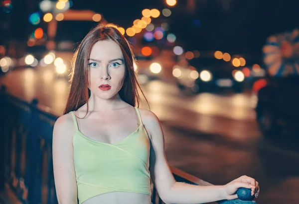 Ritratto d'arte di una bella ragazza dai capelli rossi ritratto nelle luci notturne della città. Street fashion style ritratto di giovane bella donna con lunghi capelli rossi . — Foto Stock