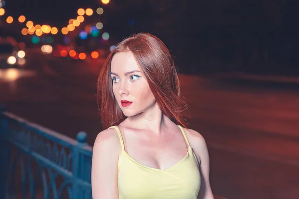Czerwony dziewczyna włosy, portret w nocy miasto ustawienie. Portret styl mody ulicznej młodych bardzo piękna kobieta z długimi rudymi włosami na sobie podkoszulek z żółtym. Dziewczyna pozuje przed światłach nocy — Zdjęcie stockowe