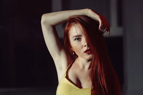 Ginger haired girl, portrait in night city setting. Street fashion style portrait of young pretty woman with long red hair posing with half face hidden by hair — Stock Photo, Image