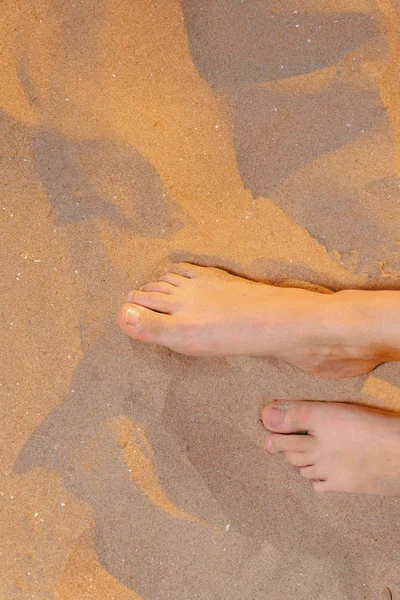 Los pies desnudos de la muchacha de arriba en la playa de arena — Foto de Stock