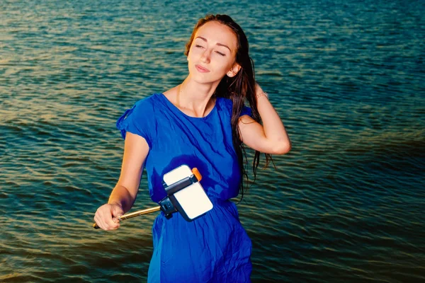 Yeşil deniz suyu önünde selfie stick kullanarak kapalı gözler kadın olun selfie — Stok fotoğraf
