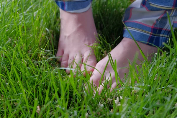 Bara fötter i färsk våren gräs. — Stockfoto