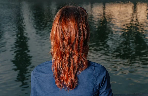 Rudowłosy dziewczyna patrząc na rzekę z odbicia miasta noc — Zdjęcie stockowe