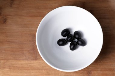 Kase yukarıdan görünüm ahşap plaka arka plan üzerinde siyah zeytin