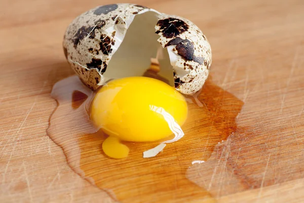 Healthy food concept - broken quail egg on wooden plate macro image — Stock Photo, Image