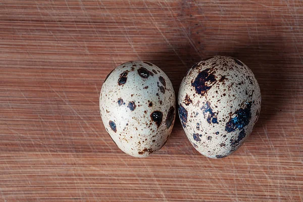 Deux oeufs de caille sur planche en bois vue du dessus — Photo