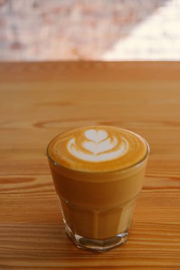Düz beyaz kahve. Düz beyaz kahve cam bir kafede ahşap tablo