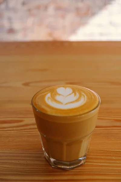 Flat white coffee. Flat white coffe glass on wooden table in a cafe