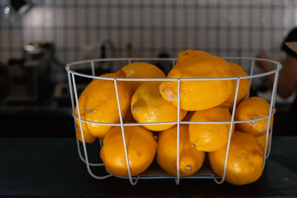 Fresh lemons. Basket of yellow lemons on cafe counter. Side view — Stock Photo, Image