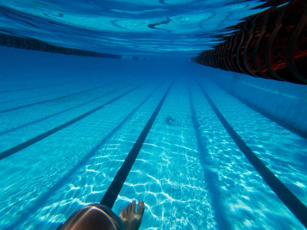 Lövés a womans láb mellett alja víz alatti pool — Stock Fotó