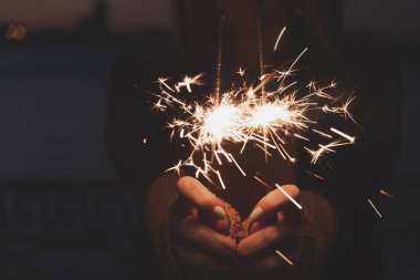 İki yanan havai fişekleri tutan eller