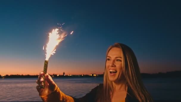Щаслива жінка розважається, насолоджуючись блискавками ввечері — стокове відео