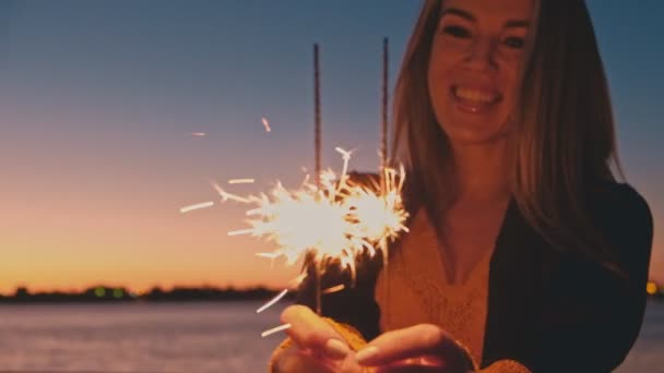 Счастливая женщина, наслаждающаяся вечером искрами — стоковое видео