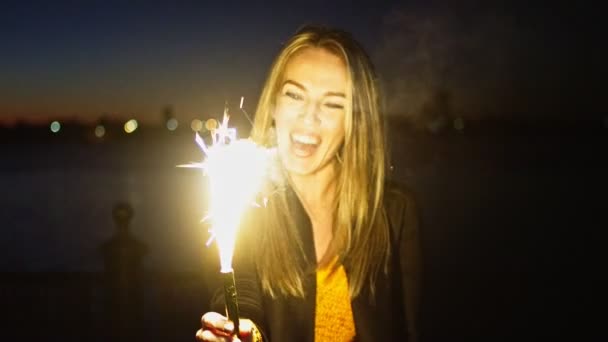 Überglückliche Frau blickt auf brennende römische Kerze in ihren Hosen — Stockvideo