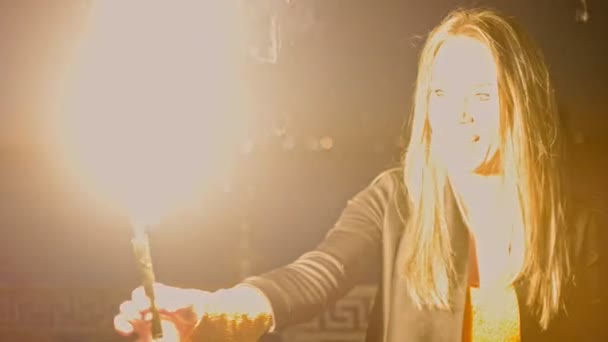 Mujer feliz mirando a la vela romana ardiendo haciendo grandes explosiones. Chica mira hacia fuera . — Vídeos de Stock