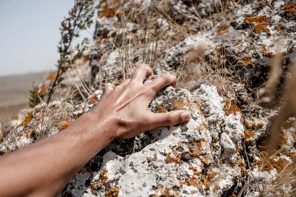 Arrampicata. Maschio mani sopra la scogliera primo piano — Foto Stock