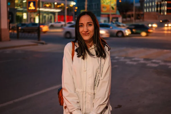 Funny girl standing in the night streets in front of city lights — Stock Photo, Image