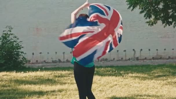 Mladá dívka soustružení Union Jack ve svých rukou — Stock video