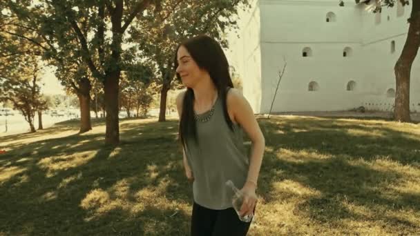 Sommaren porträtt av glad hoppande tjej med flaska vatten i händer — Stockvideo
