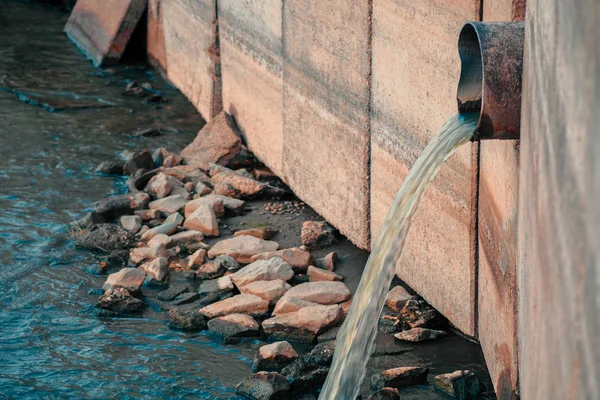 Ciudad Contaminando el medio ambiente. Tubo de drenaje que descarga productos de la cintura directamente en el río — Foto de Stock