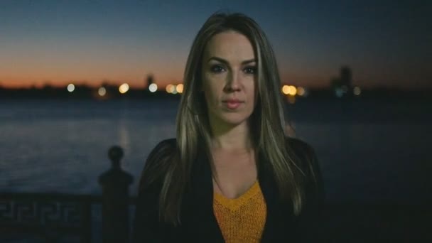 一个冷静的女人站在外面的黑暗中 看着相机慢镜头 — 图库视频影像