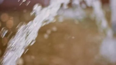 Su akıntısı yavaş çekimde havada uçuyor ve yapay göletten aşağı düşüyor.